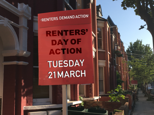 Join the Renters' Day of Action Tuesday 21 March on a board or placard, planted outside a terraced house on a sunny day